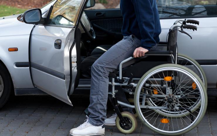 Disabile in sedia a rotelle che entra nella sua auto
