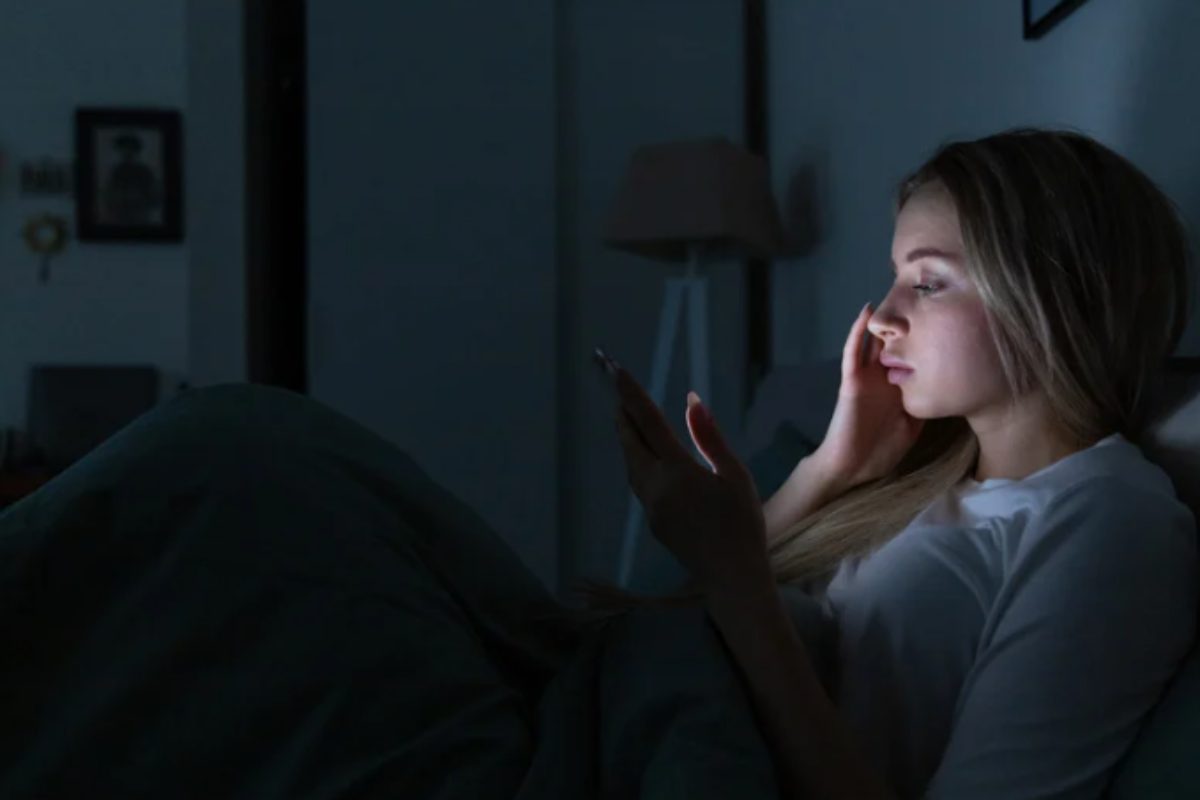 donna controlla cellulare di notte